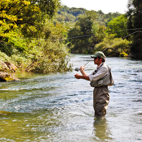 Experienced guide while fishing in the river in Trentino