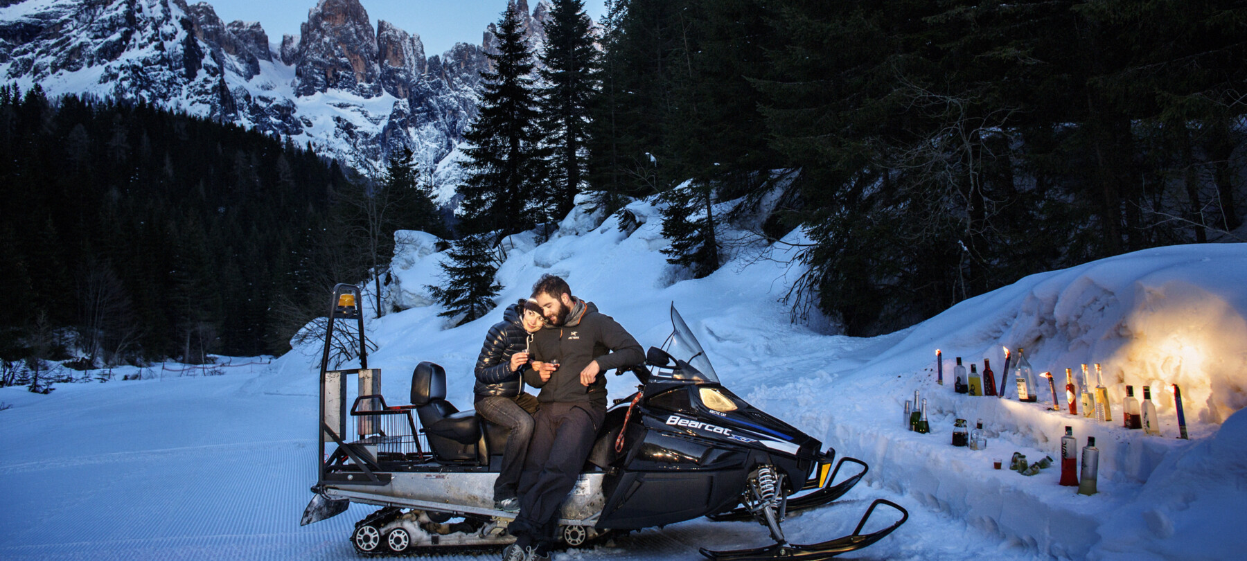 Enjoy an apéritif while admiring the Dolomites after a fun snowmobile ride 