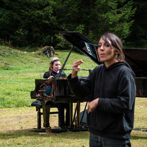 Während der Künstler mit Klavierbegleitung singt, übersetzt der Gebärdensprachen-Dolmetscher den Text des Liedes in Gebärdensprache.