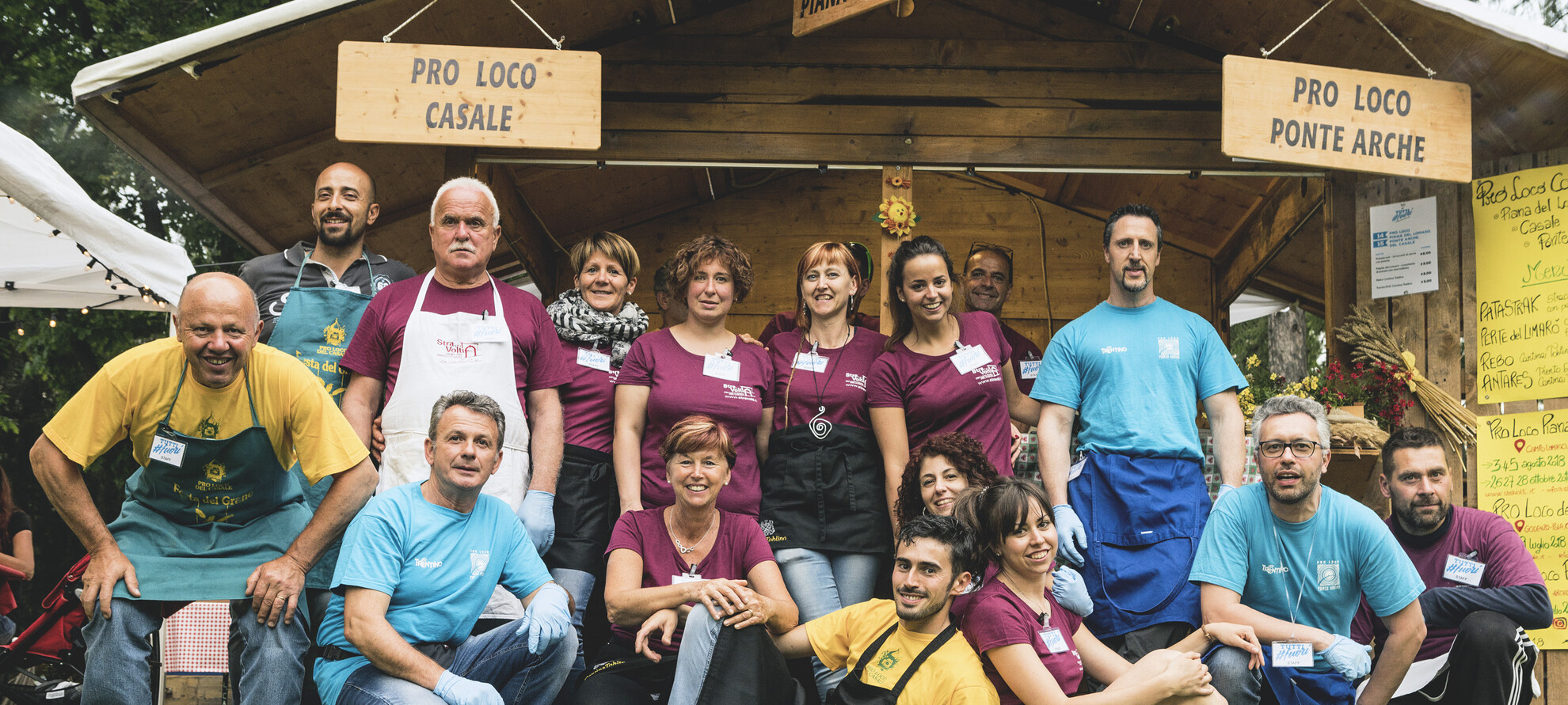 Group photo of some volunteers of the Tutti #Fuori event, the great travelling festival organized by the Trentino Pro Loco associations. The colours of the t-shirts they are wearing tell us that they are volunteers from different Pro Loco associations. But here they work together, and together they celebrate their commitment.