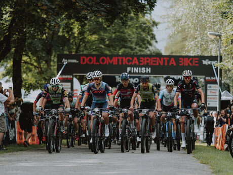Group of cyclists racing at the start of the Dolomitica Brenta Bike.