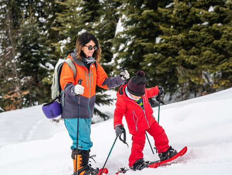 Mutter und Kinder mit Schneeschuhen auf der Pinguino-Loipe in Paganella