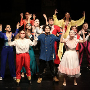 L'immagine mostra alcuni ragazzi del camp di teatro mentre sono in scena sul palco