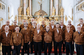 L'immagine mostra i componenti del coro alpino trentino mentre eseguono un concerto in una chiesa