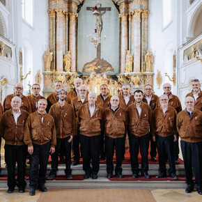 L'immagine mostra i componenti del coro alpino trentino mentre eseguono un concerto in una chiesa