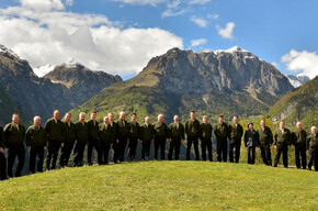 L'immagine mostra i componenti del coro cima Ambiez; sullo sfondo la maestosa cima da cui il coro prende il nome