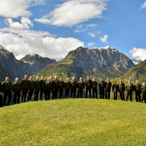 L'immagine mostra i componenti del coro cima Ambiez; sullo sfondo la maestosa cima da cui il coro prende il nome