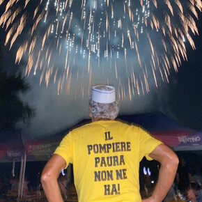 man with his back to the fireworks, on his shirt is the inscription ‘The fireman is not afraid’.