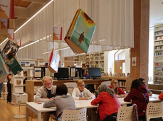 Sala di una biblioteca con persone intorno a un tavolo