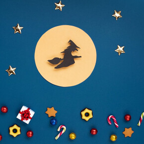 Nell'immagine si vede la befana disegnata su cartincino , mentre vola con la scopa nella luna piena. In basso dei dolcetti decorano il foglio