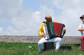 L'immagine mostra i due artisti mentre suonano in un prato.