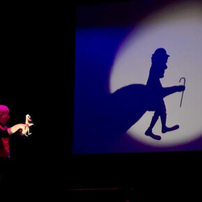 Nell'immagine si vede l'artista mentre fa giochi d'ombre con le mani
