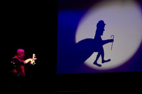 Nell'immagine si vede l'artista mentre fa giochi d'ombre con le mani