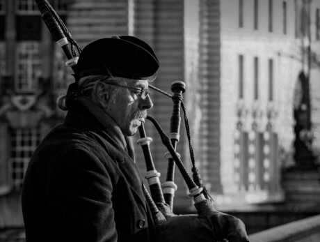 Zampognari ad Andalo Un uomo suona la cornamusa in una foto in bianco e nero.