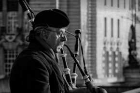 Un uomo suona la cornamusa in una foto in bianco e nero.