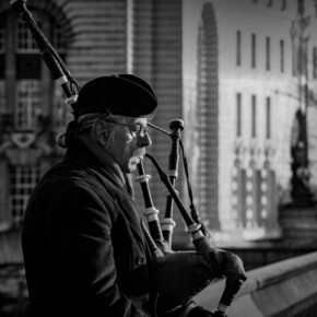 Un uomo suona la cornamusa in una foto in bianco e nero.
