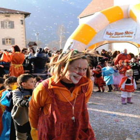 A friendly clown playing with children in the square with confetti and sparklers.