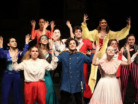 L'immagine mostra alcuni ragazzi del camp di teatro mentre sono in scena sul palco
