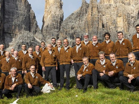 L'immagine mostra il coro Campanil Bas mentre canta ai piedi dell'omonima cima tra le Dolomiti di Brenta