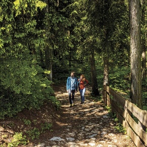 Una coppia cammina lungo i sentieri del Parco del Respiro a Fai della Paganella.
