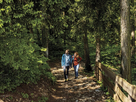 A couple walks along the paths of the Respiro Park in Fai della Paganella.