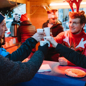 La foto immortala il momento del brindisi tra quattro amici che brindano al natale