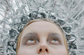  L'immagine raffigura la Regina delle Nevi, con un copricapo argentato ispirato al ghiaccio e un trucco etereo che richiama l'inverno. Lo sfondo naturale innevato enfatizza l'atmosfera magica e invernale.