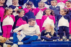 Children on stage, ready to sing a song.