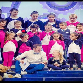 Children on stage, ready to sing a song.