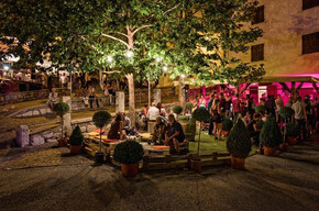 Uno stand dove le persone si rilassano e bevono un calice di vino.