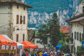La foto ritrae il paese in festa. Molte persone riempiono il viale principale del paese tra stand enogastronomici e buona compagnia.